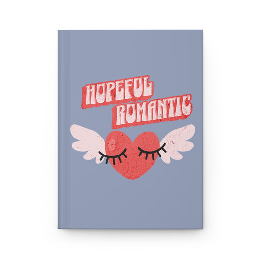 Notebook with a retro style red heart with wings and flirty eyelashes design and 'Hopeful Romantic' text written in retro aesthetic font, on a light blue jean colored background