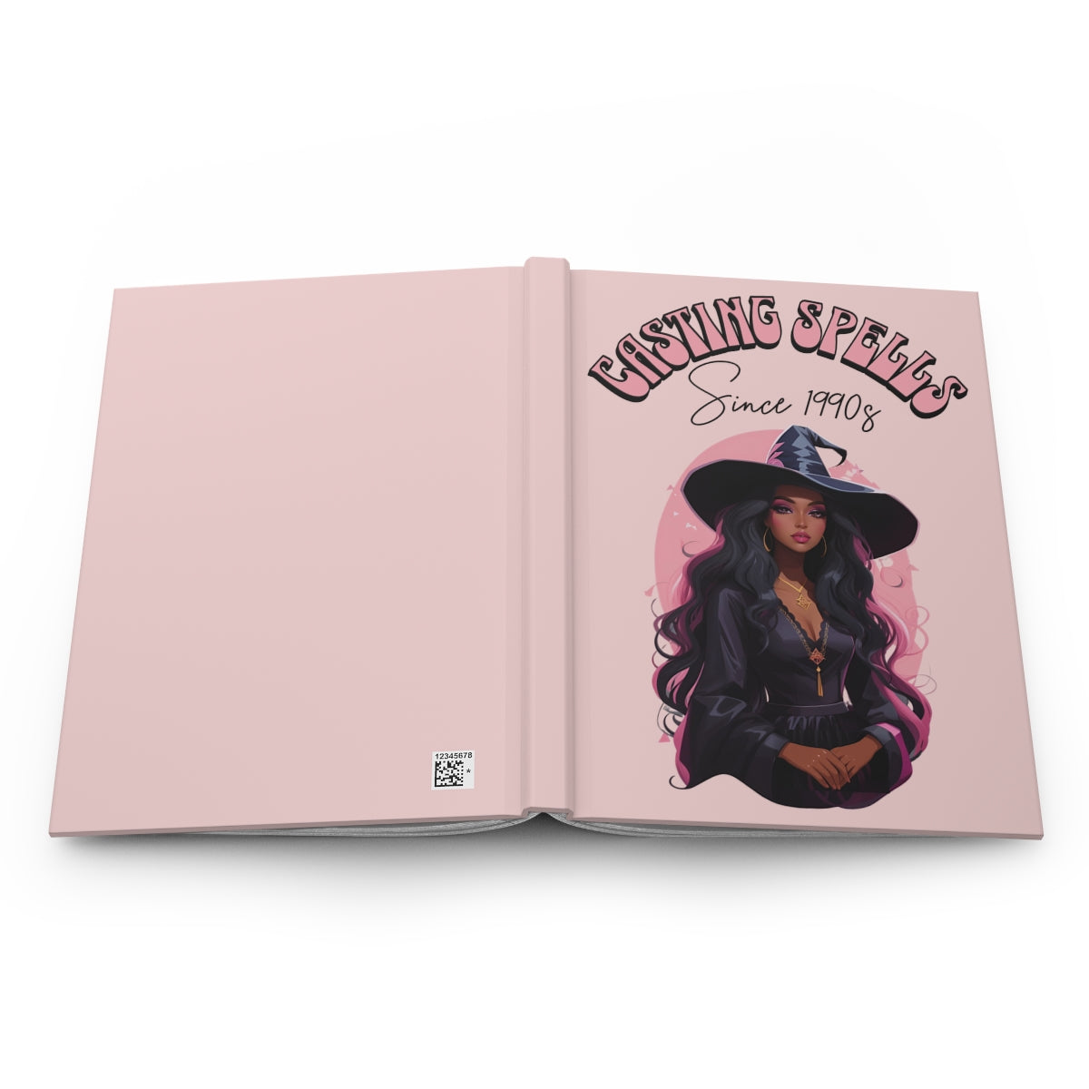 Open hardcover notebook with a light pink cover featuring an illustration of a very beautiful black woman in a witch's hat and text 'Casting Spells Since 1990s' written in retro aesthetic letters.